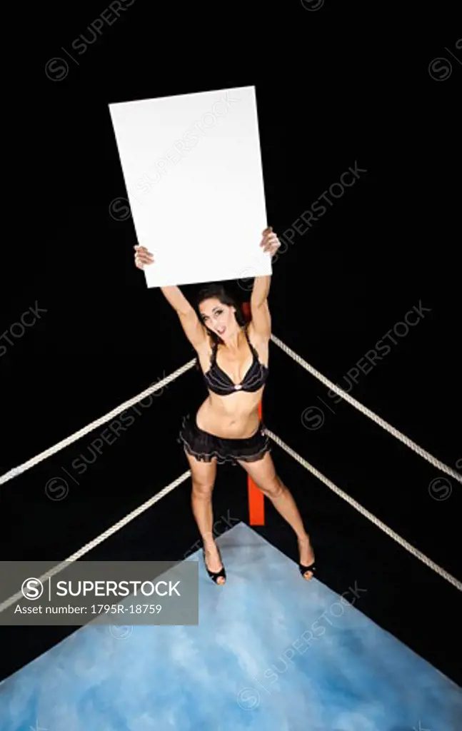 Ring girl holding sign in corner of boxing ring