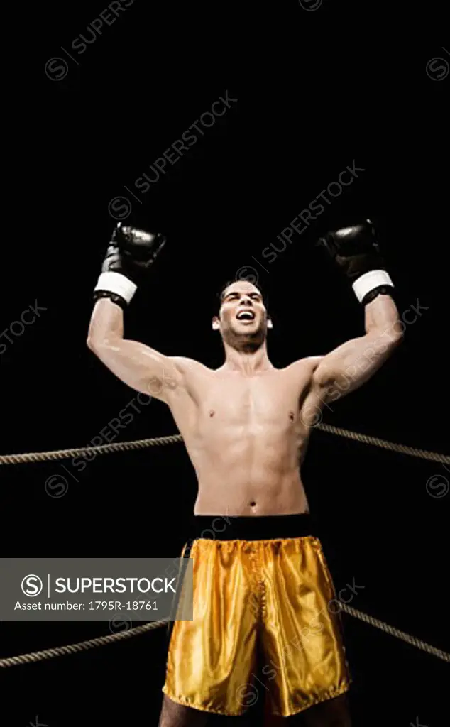 Boxer celebrating in corner of boxing ring