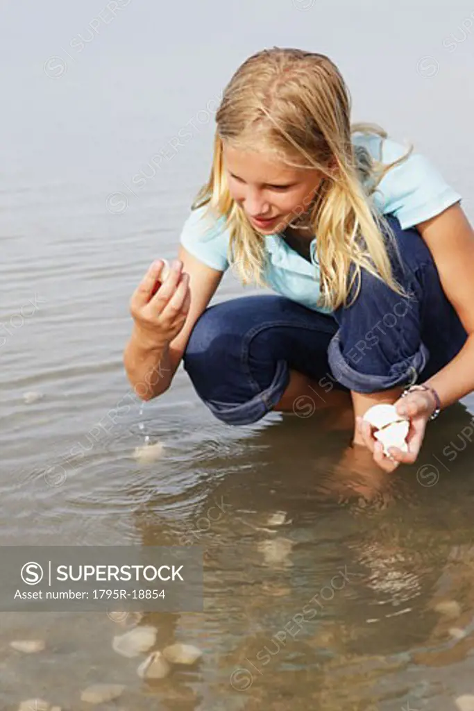 Girl finding seashells in ocean