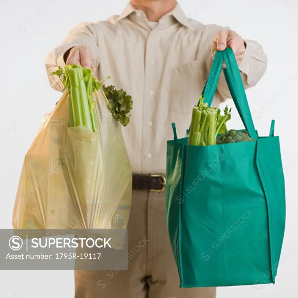 Man holding reusable grocery bags