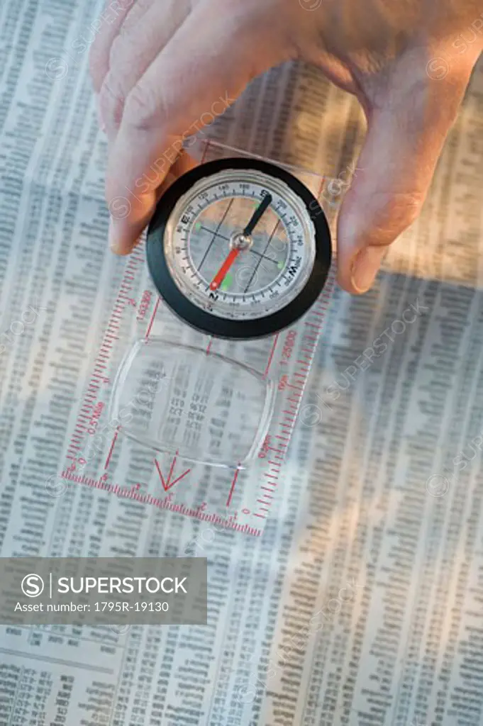 Man holding compass over stock pages