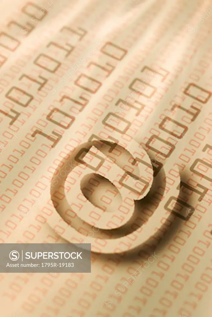 Close-up of ""at' symbol and binary code