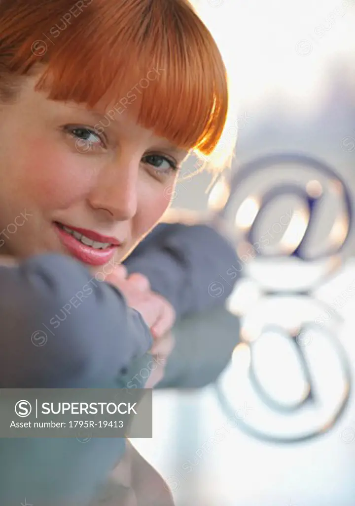 Woman looking at ""at"" symbol
