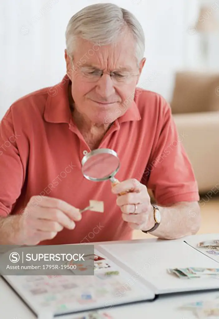 Senior man looking at stamp collection