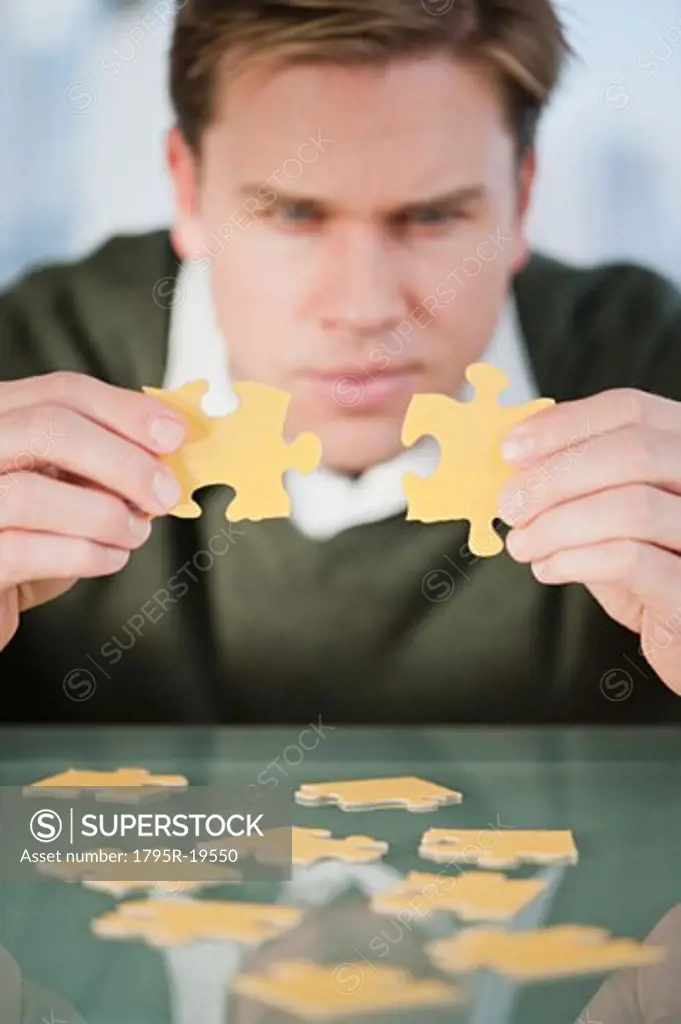Businessman looking at puzzle pieces