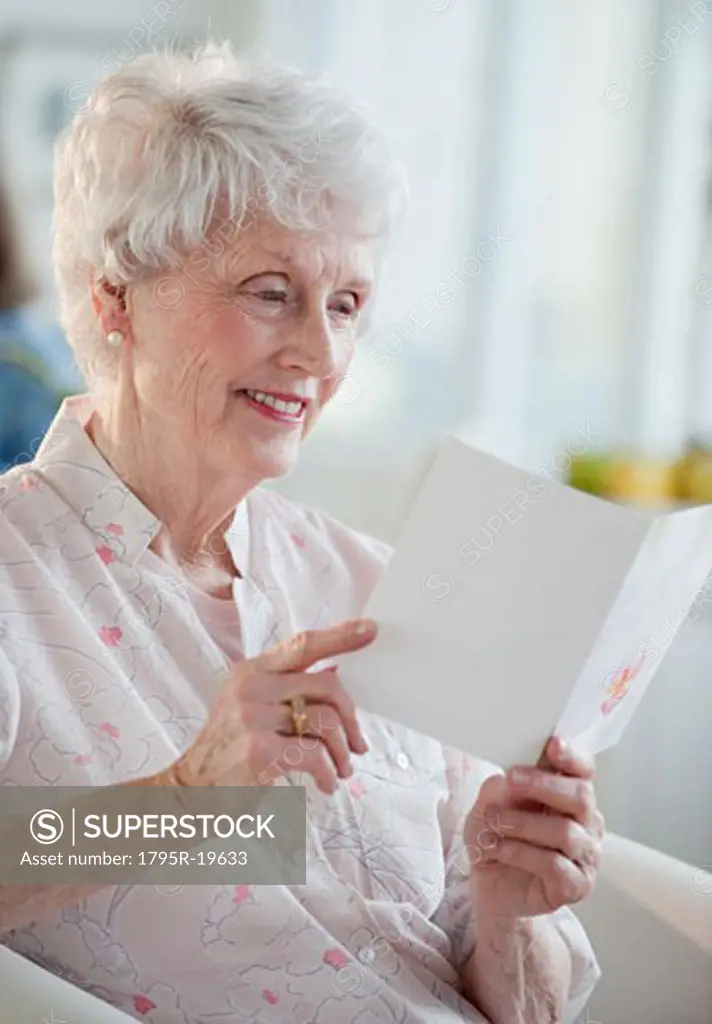 Senior woman reading greeting card