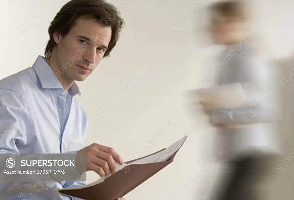 Man holding file with person passing