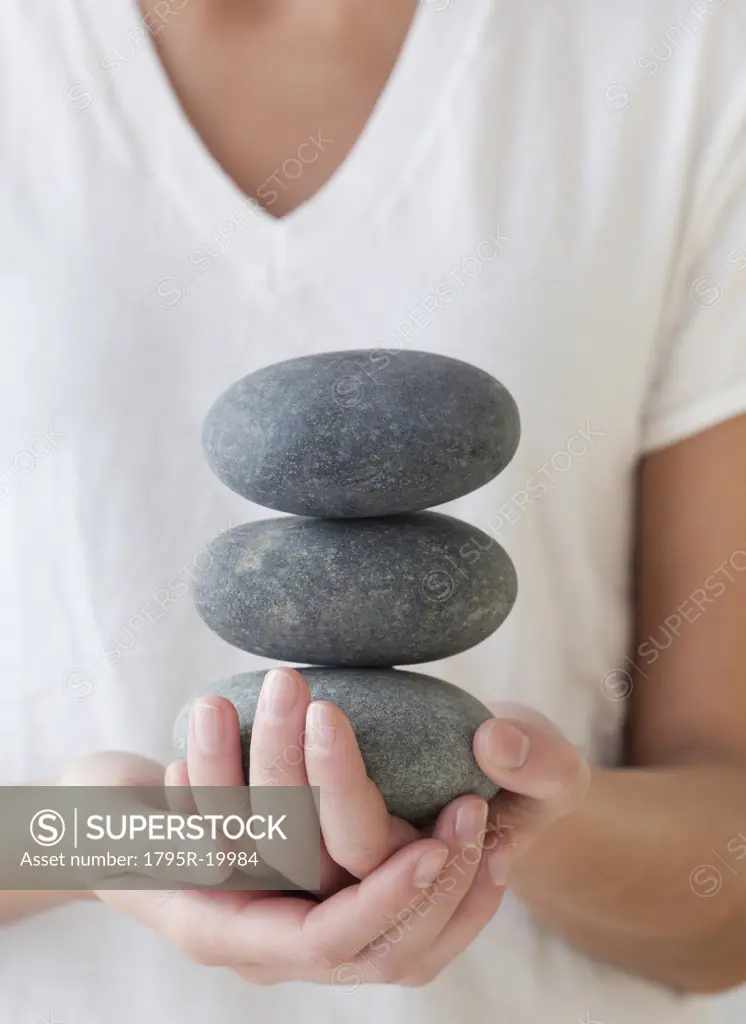 Woman holding stack of spa stones