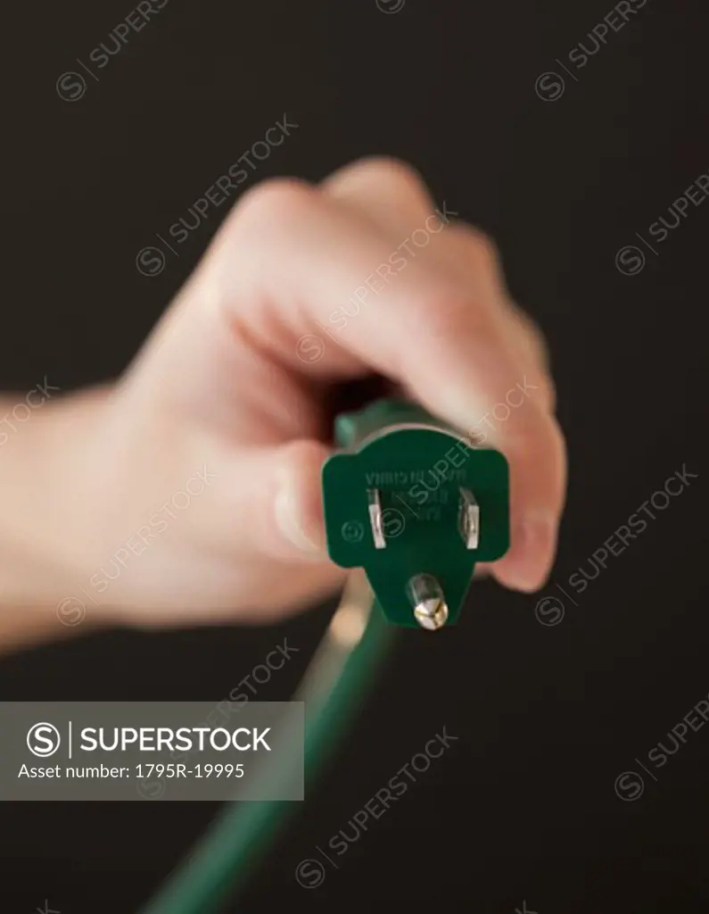 Close-up of hand holding electric plug