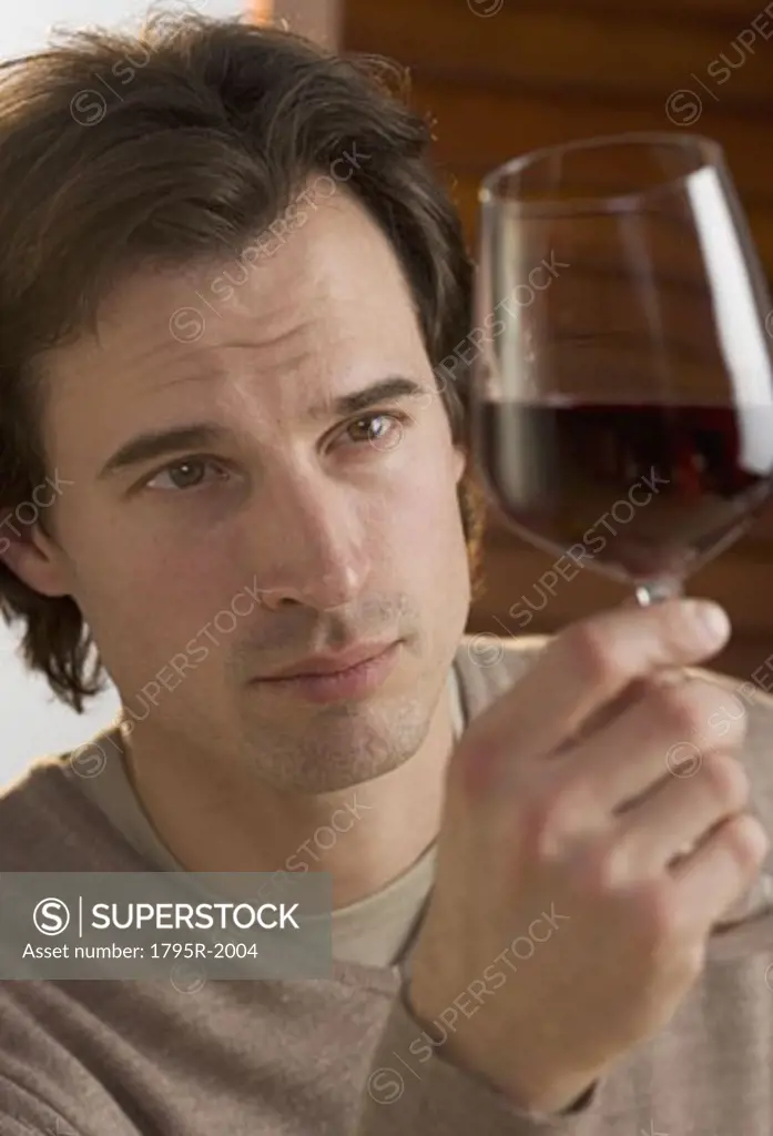 Closeup of man examining red wine