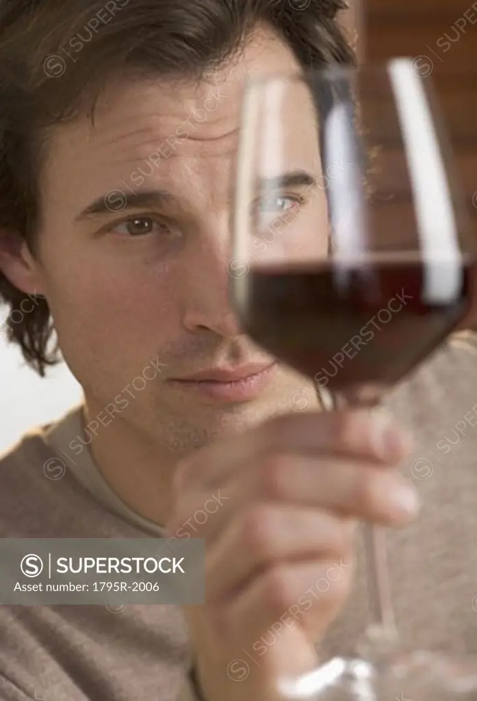 Closeup of man scrutinizing red wine