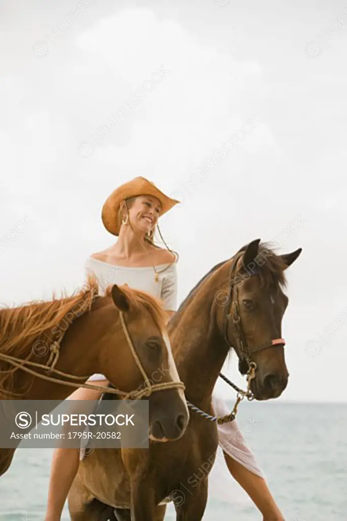 Woman riding horse on beach