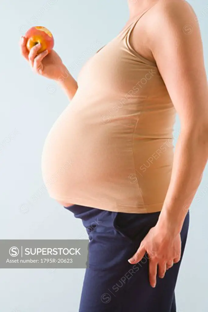 Pregnant woman eating apple