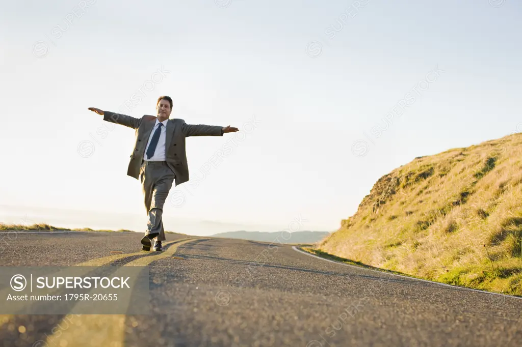 Businessman running on remote road