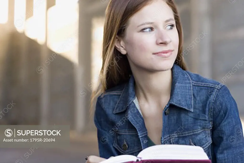 Young woman reading in urban setting