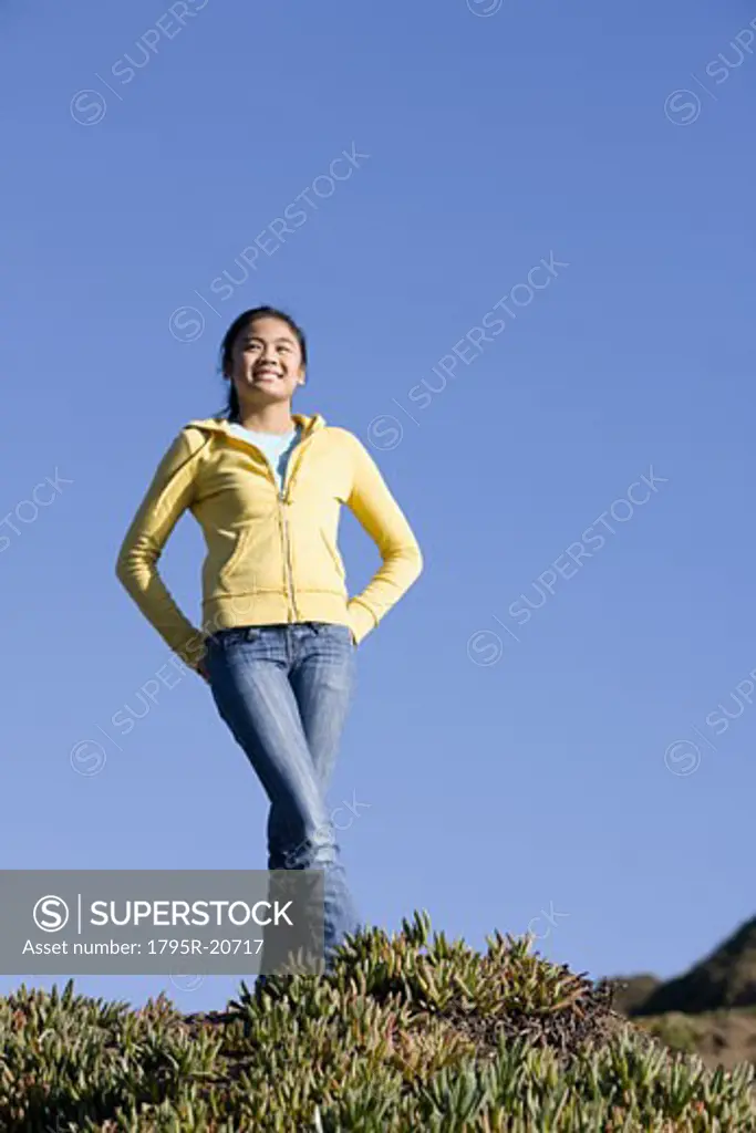 Teenage girl standing on hill