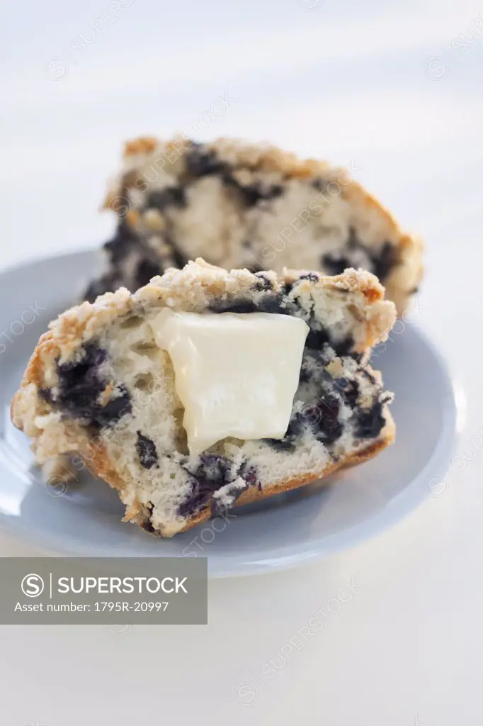 A blueberry muffin with butter
