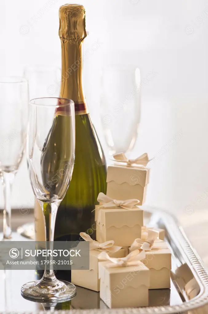 Champagne on a tray with small gift boxes