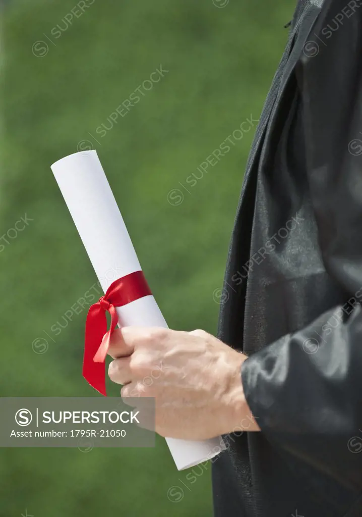 A graduate holding a diploma