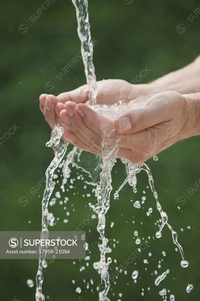 Hands under pouring water
