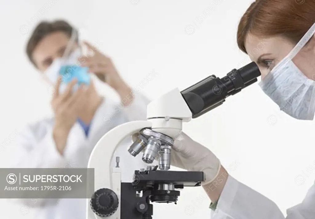 Scientists in laboratory with microscope