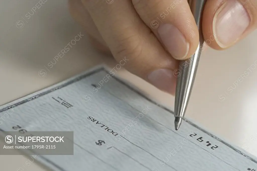 Closeup of hand writing check