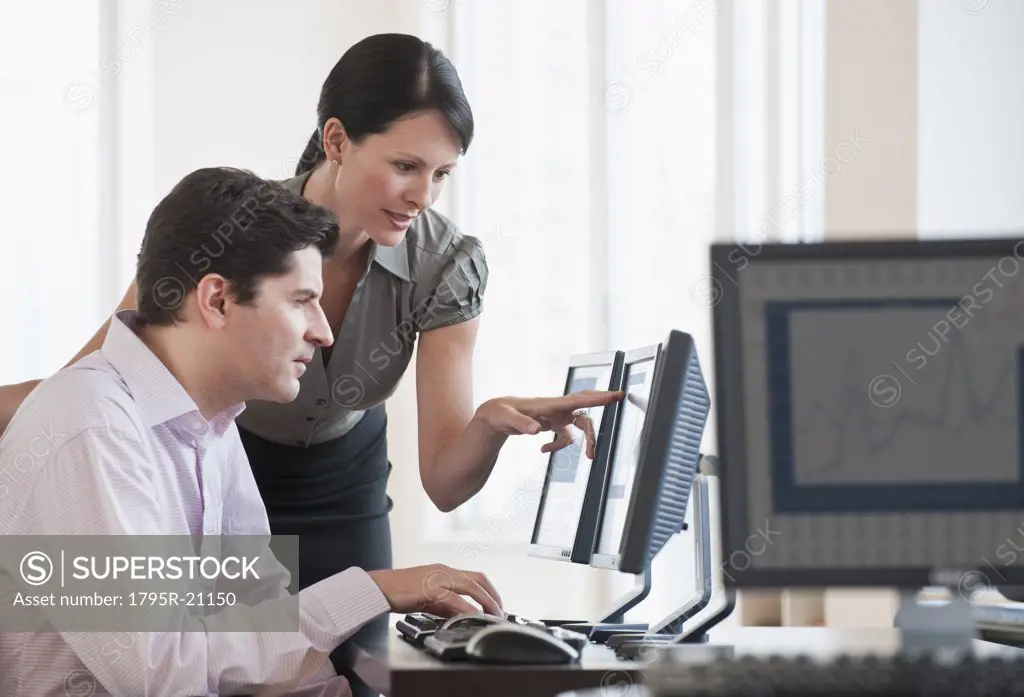 Two business people using a computer