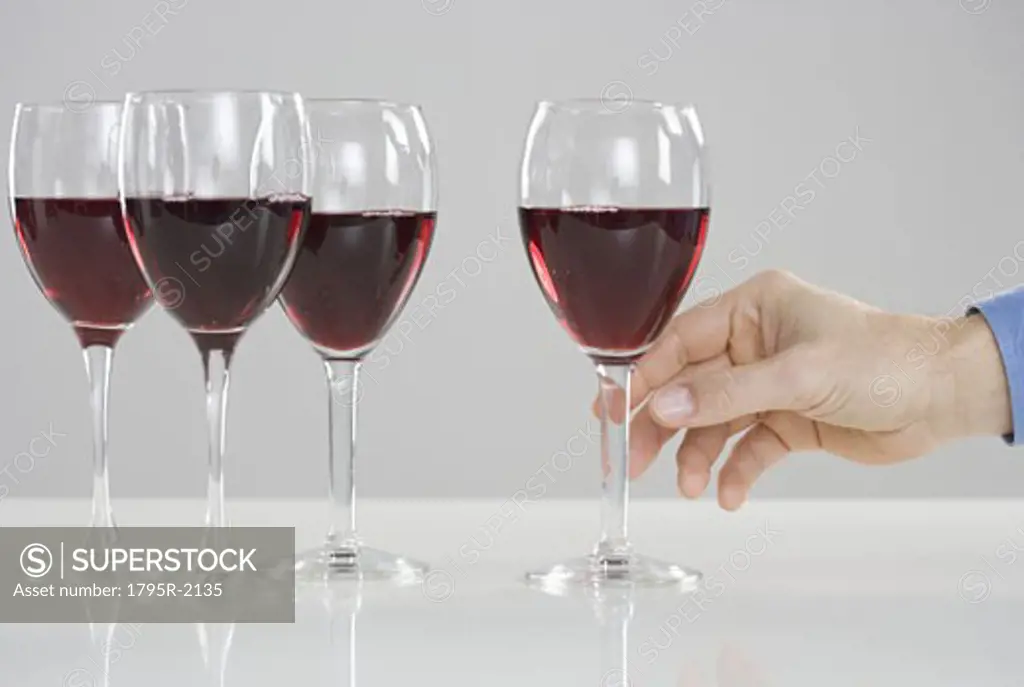 Hand reaching for glass of wine