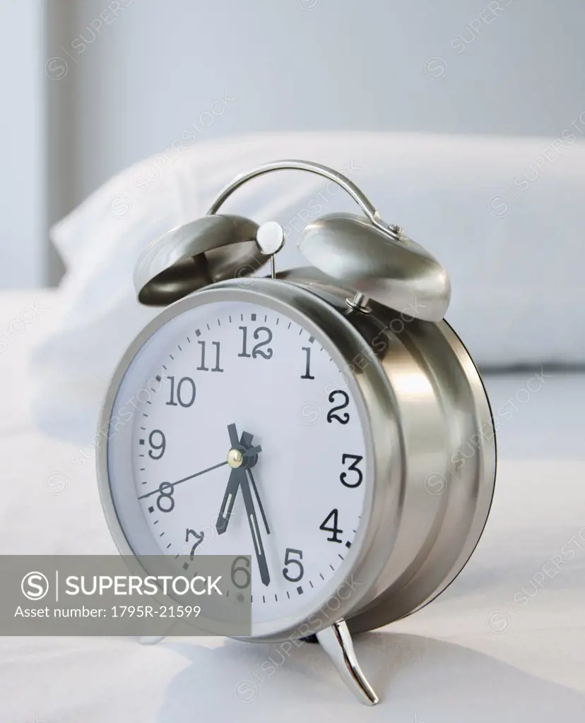 An alarm clock on a bed