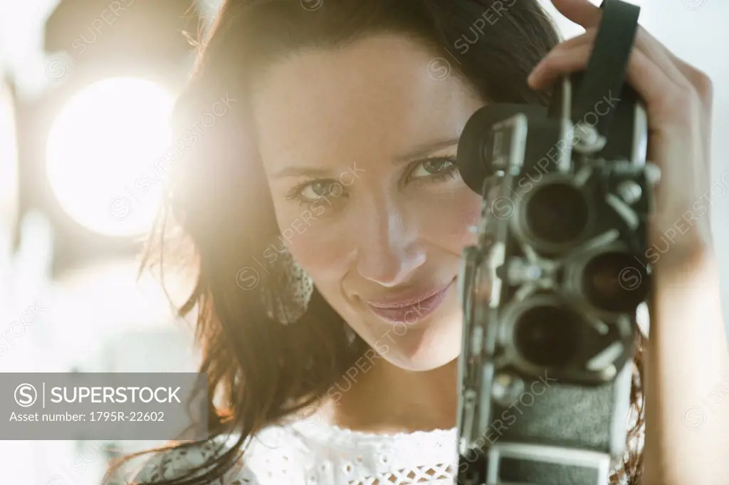 Portrait of female filmmaker using film camera