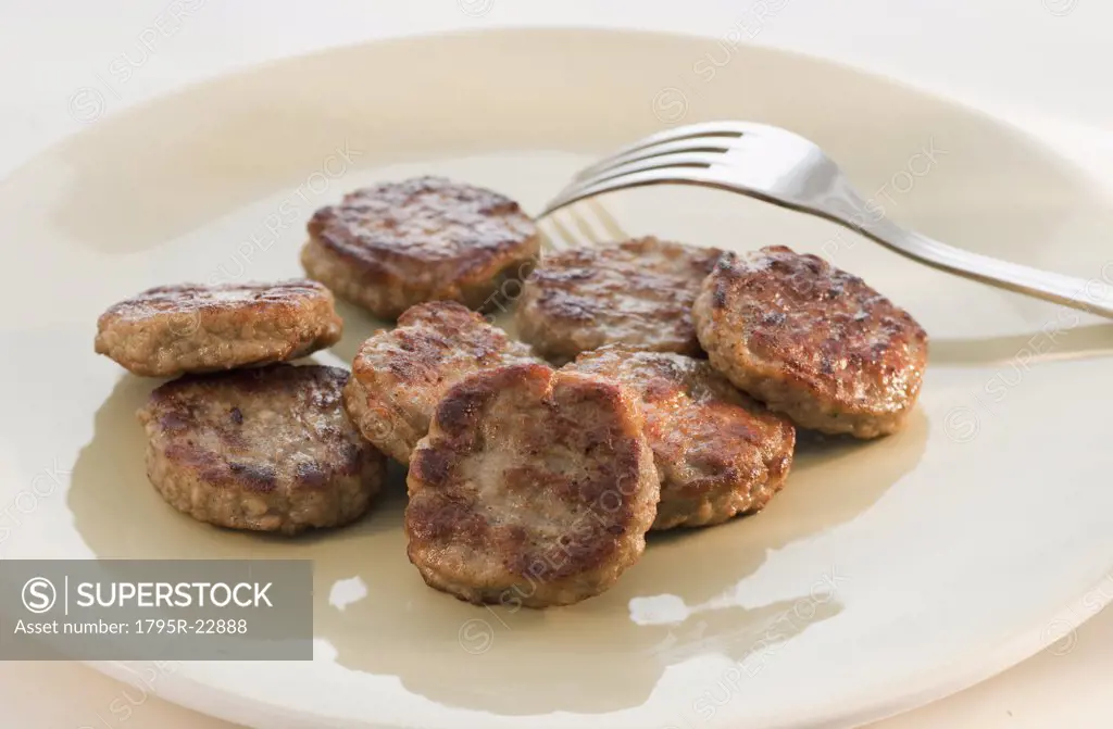 Fried slices of sausage and fork on plate