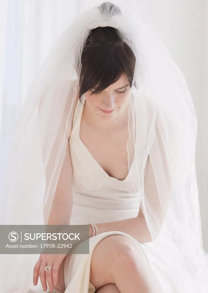 Pensive bride in wedding dress, studio shot
