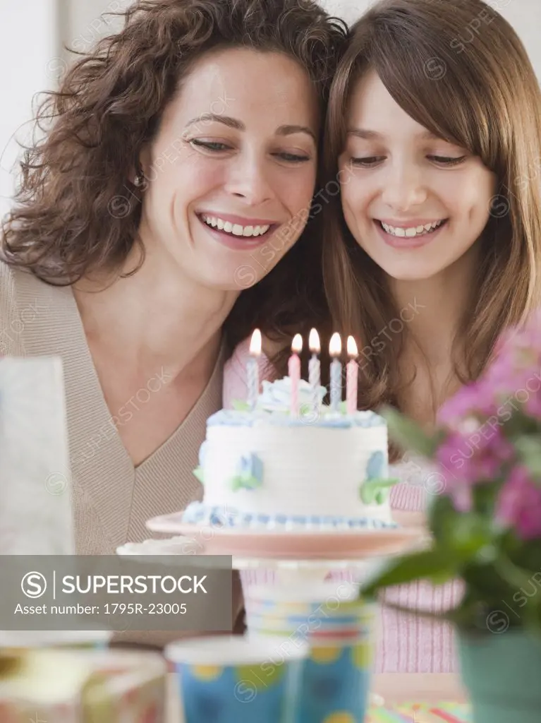 Girl (10-12 years) celebrating birthday with mother