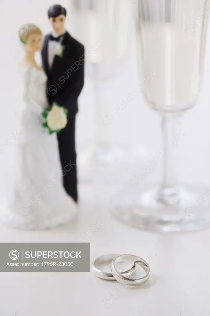 Wedding rings by bride and groom cake toppers and wineglasses