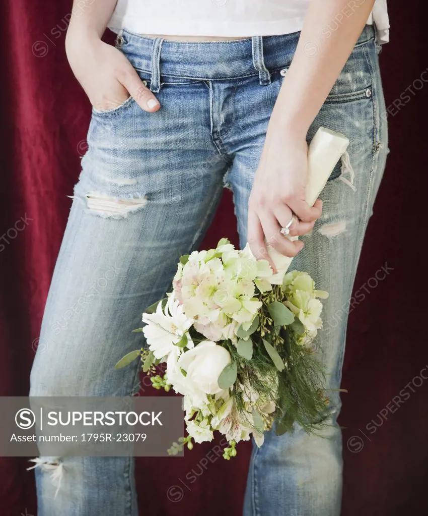 Woman in jeans holding bouquet of flowers