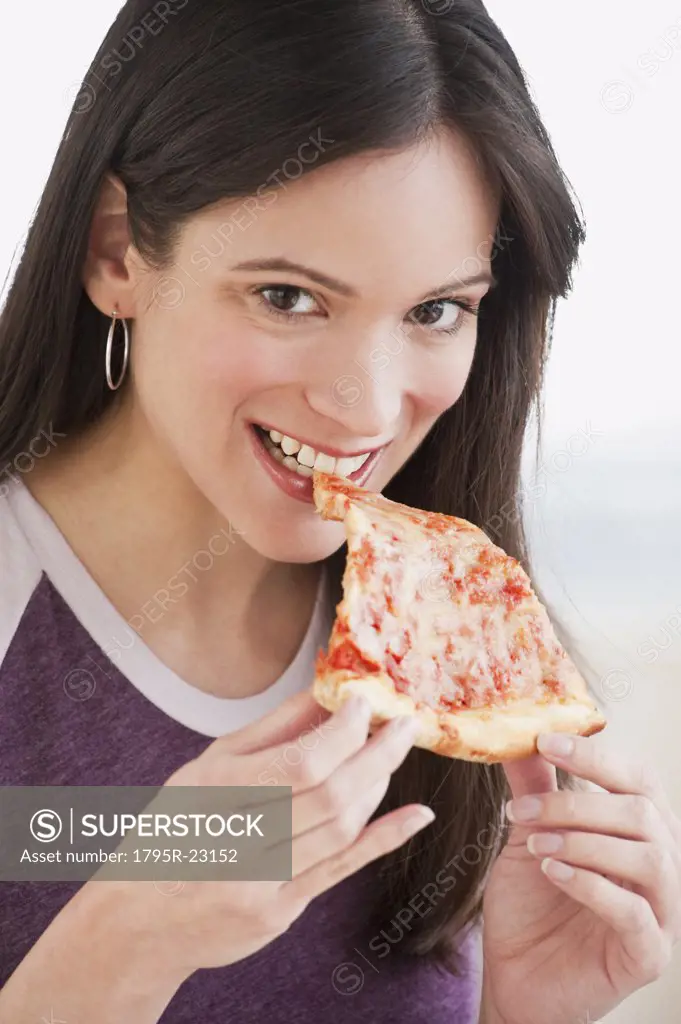 Portrait of woman eating pizza slice