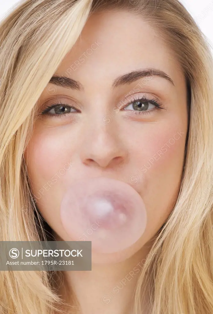 Studio portrait of young woman blowing bubble