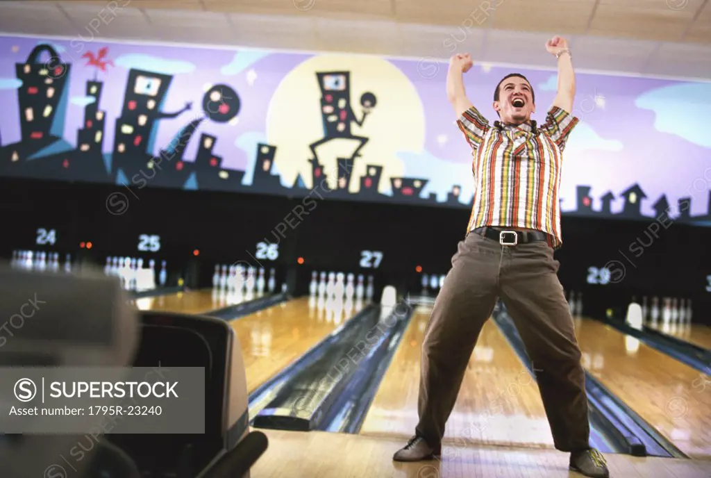 Man standing in front of bowling alley and cheering