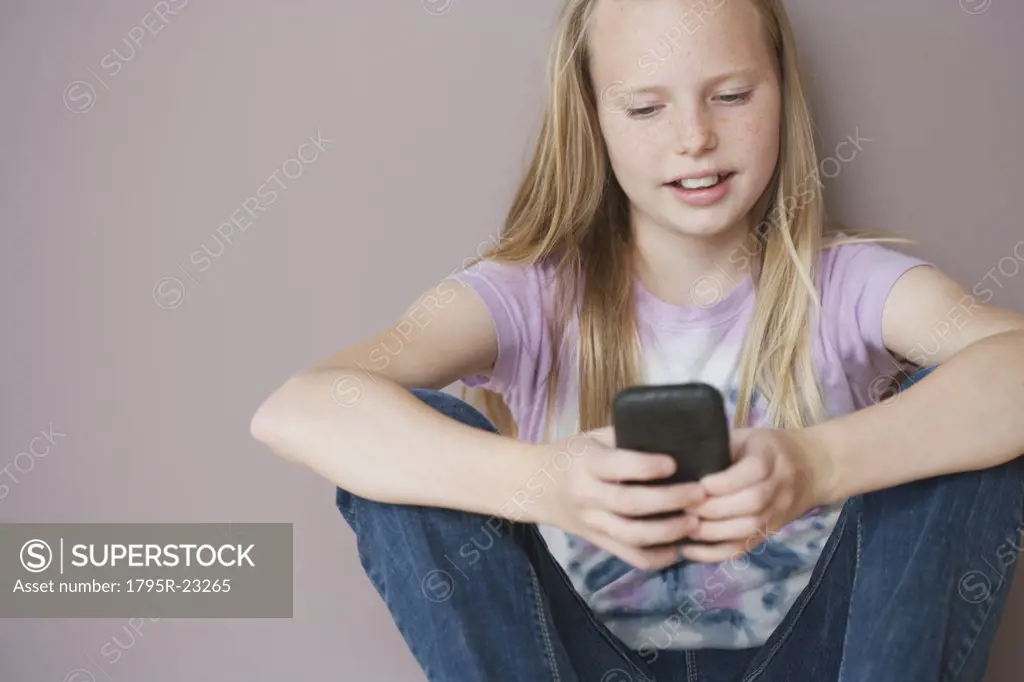 Girl (10-12) sitting and text messaging