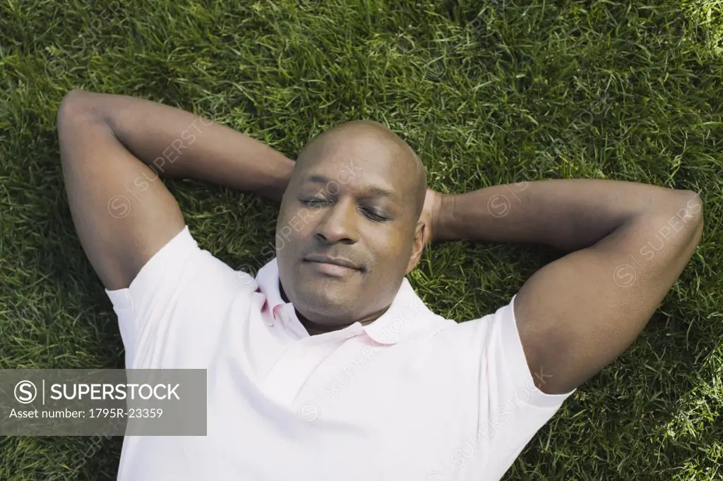 Bald man relaxing on grass
