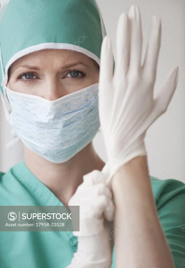Female doctor putting on gloves