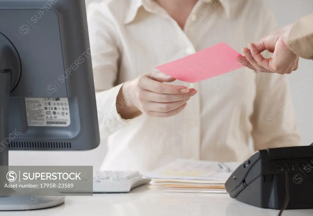 Hand passing note to office worker