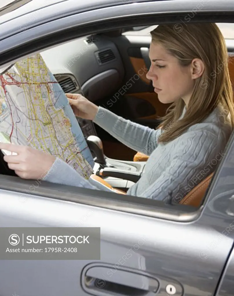 Woman in car looking at a map
