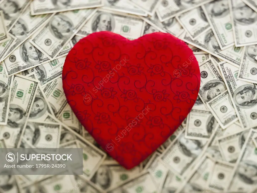 Symbolic red heart with US dollars as background