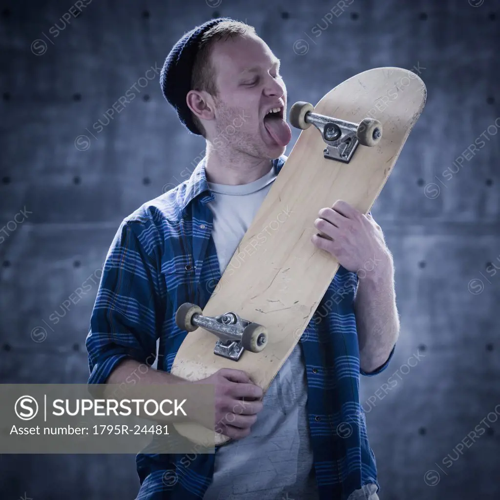 Male skateboarder licking board