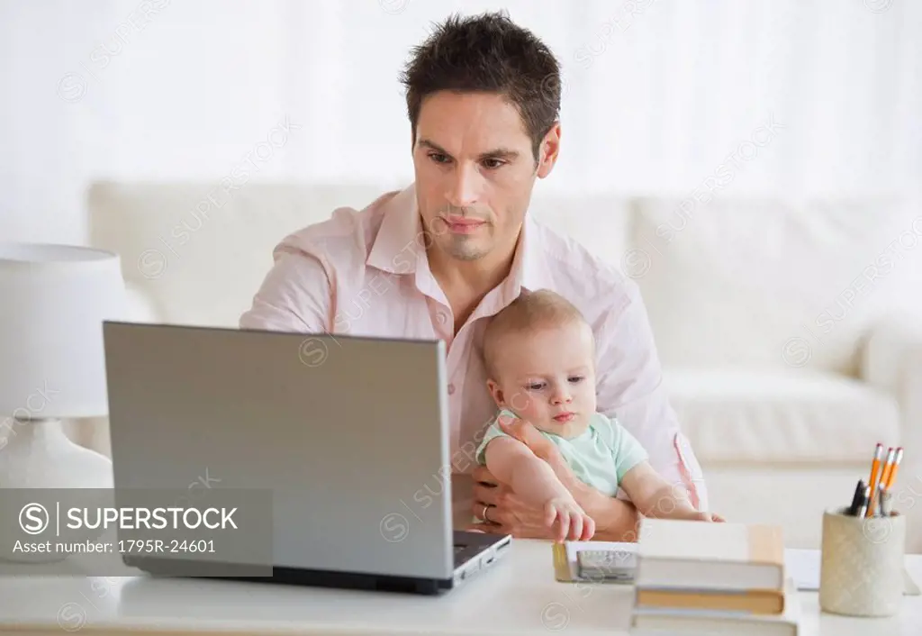 Man holding baby while working