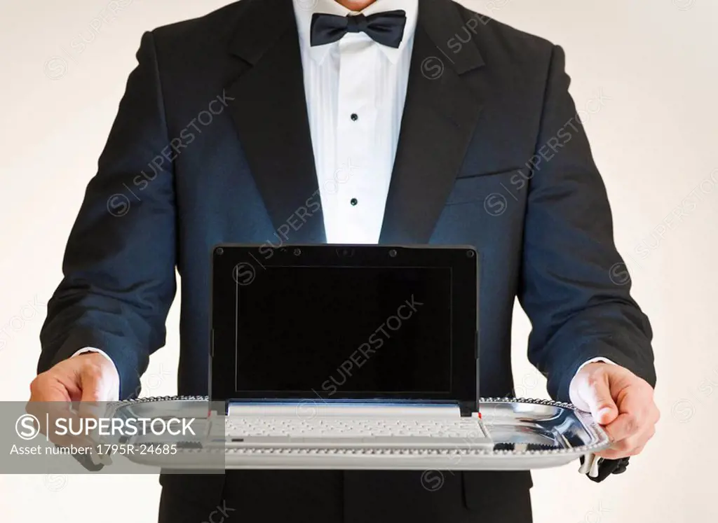Butler holding laptop on tray