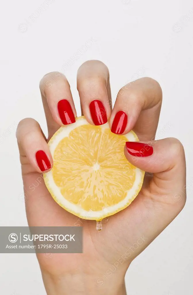 Hand holding slice of lemon