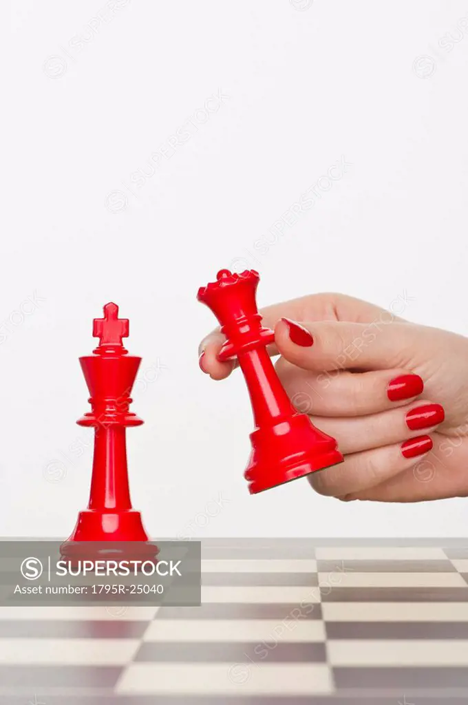 Hand holding red chess piece