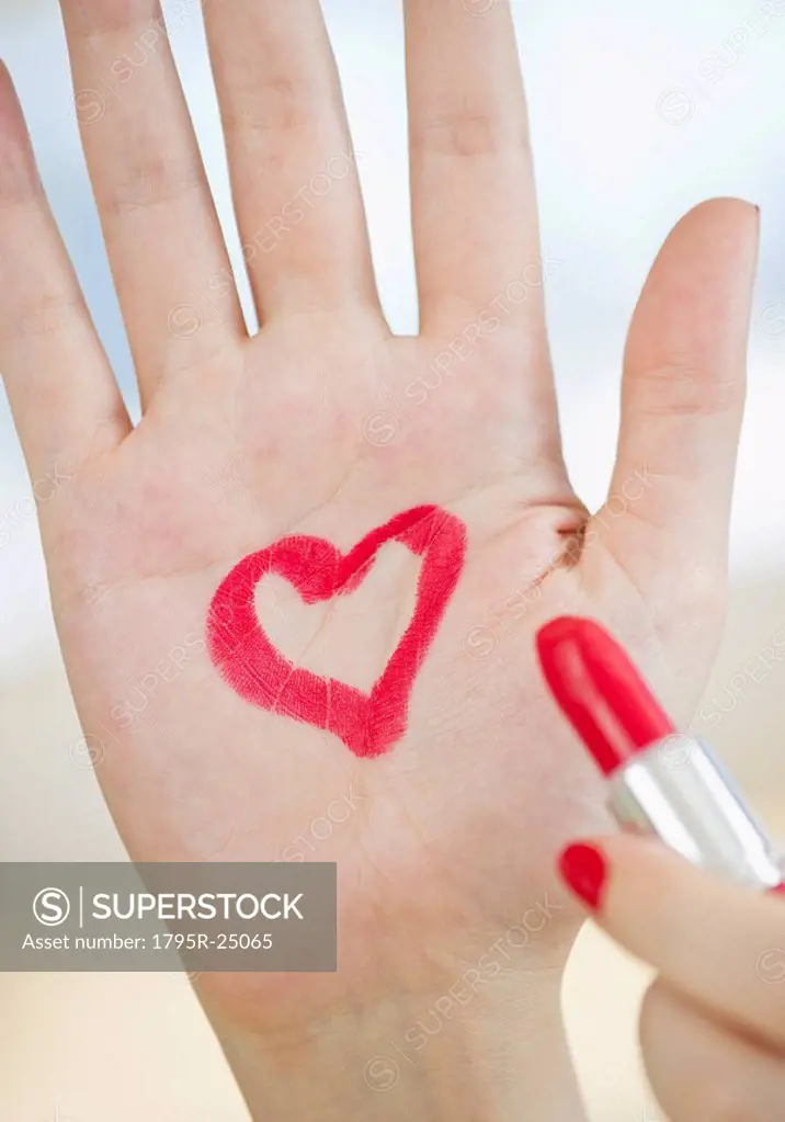 Red heart drawn on hand with lipstick